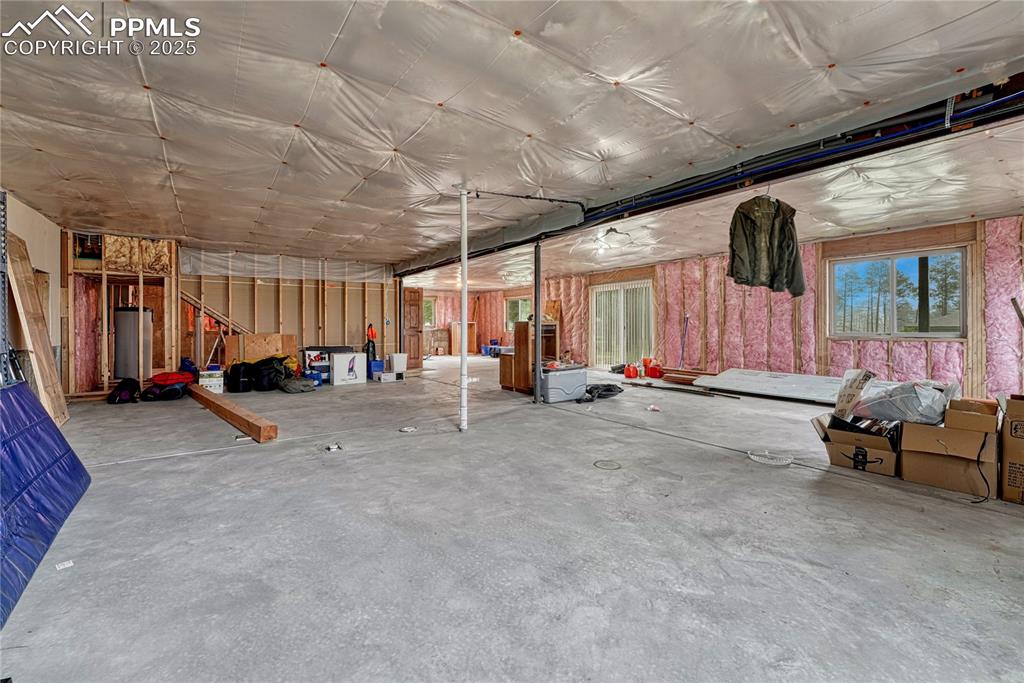 Miscellaneous room featuring concrete flooring and water heater