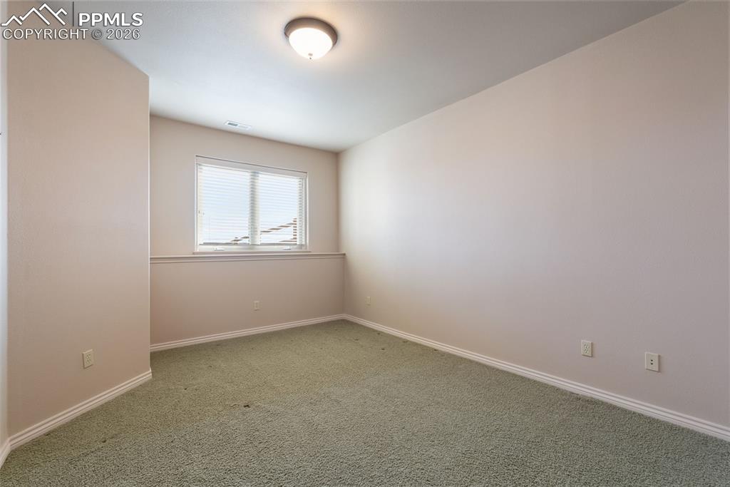 Carpeted spare room with baseboards