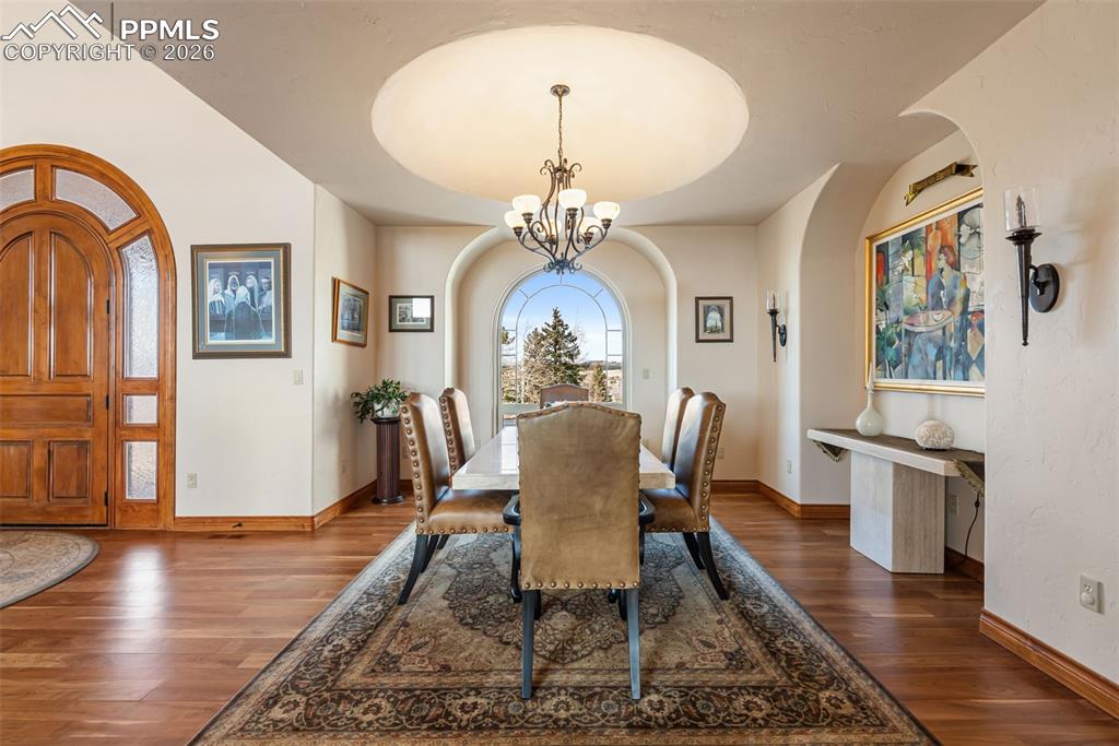 Dining space featuring hanging lights and dark wood-type flooring