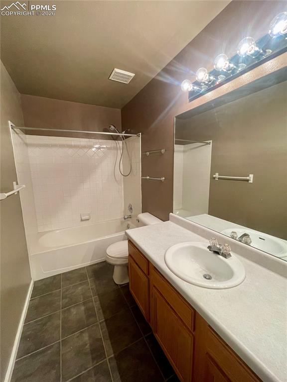 Full bath with vanity,  shower combination, and dark tile patterned floors