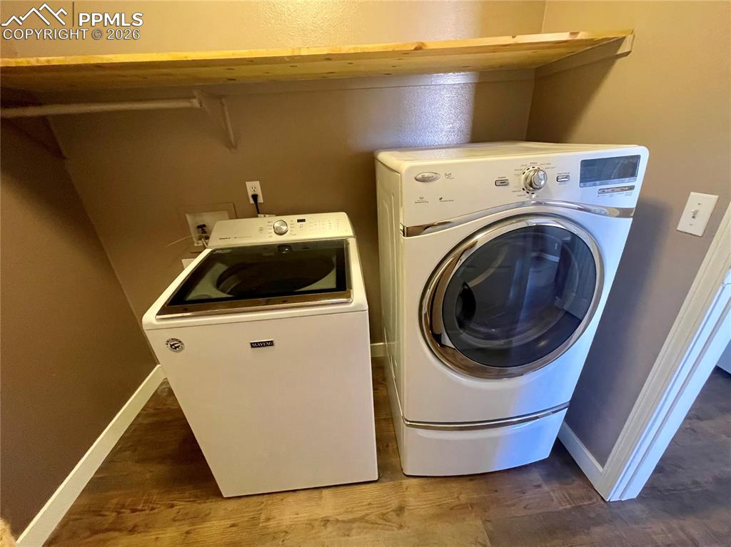 Laundry room with dark wood-style floors and washer and dryer