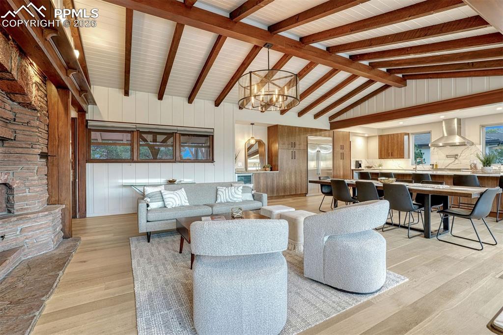 Living area with fireplace, white oak hardwood floors, and window wall overlooking serene views.