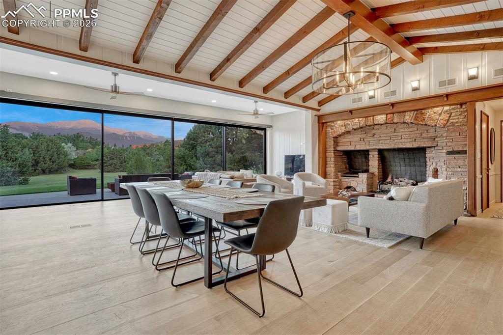 Sun-filled living and dining areas with a fireplace, rich white oak floors, and a window wall that invites the surrounding landscape inside.