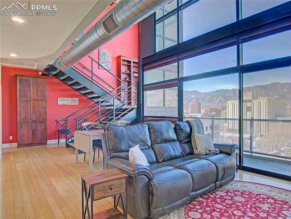 Living room featuring a mountain view, light wood finished floors, recessed lighting, and a high ceiling