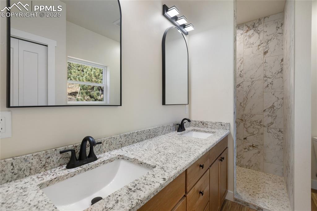 Bathroom with double vanity and a tile shower