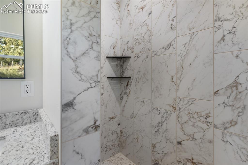 Full bathroom with a marble finish shower and vanity