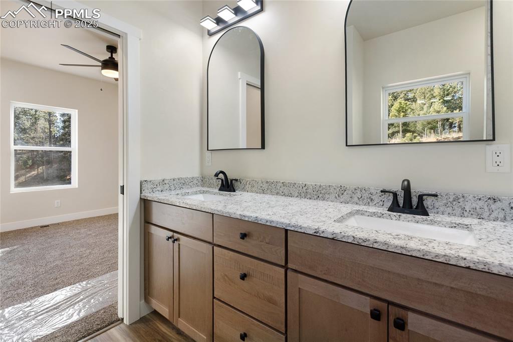 Full bathroom with plenty of natural light, double vanity, ceiling fan, and dark wood finished floors