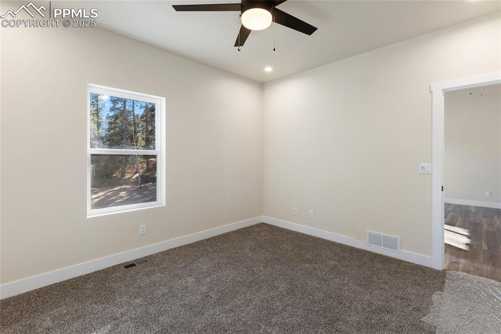 Spare room featuring dark colored carpet, recessed lighting, and ceiling fan