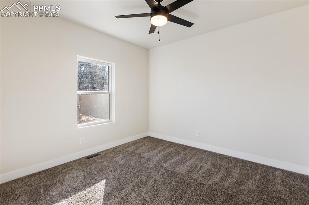 Empty room with carpet flooring and ceiling fan