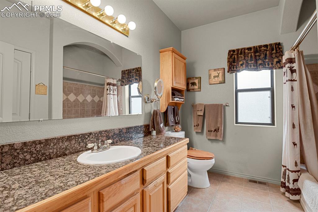 Full bath with vanity and tile patterned flooring
