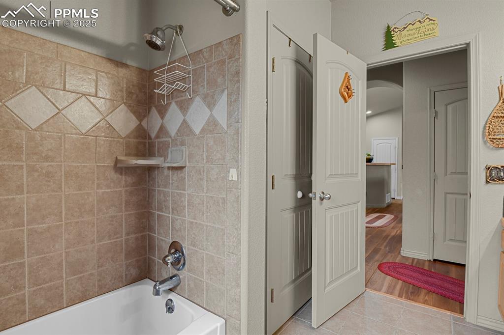 Full bath with  shower combination and tile patterned flooring