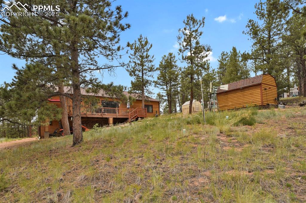 View of yard featuring a deck and an outdoor structure