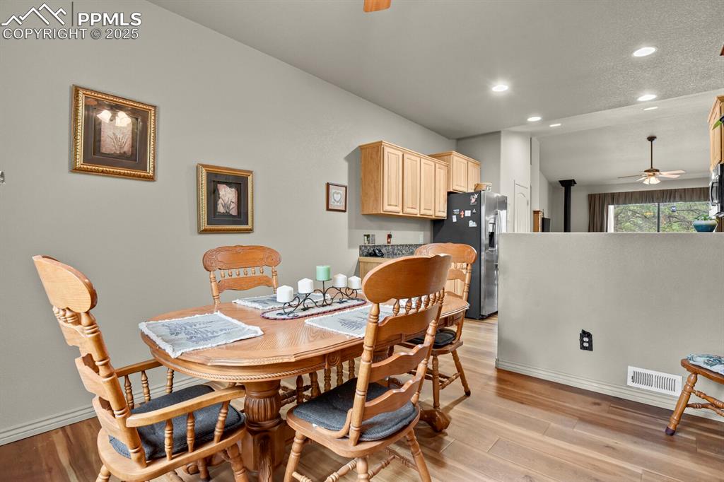 Dining space with a ceiling fan, recessed lighting, and light wood finished floors