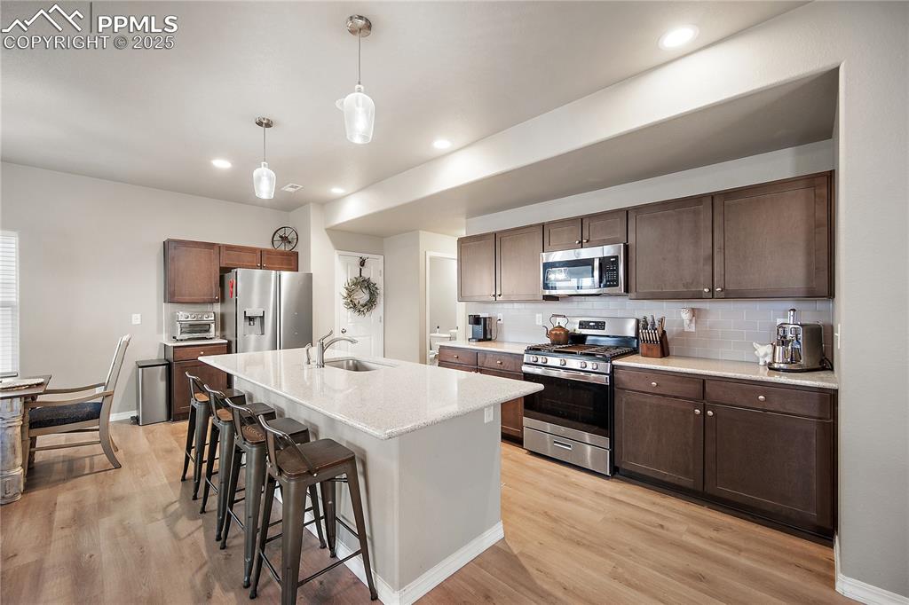 Huge island, gas range, SS applainces, darker wood cabinetry, kitchen pantry