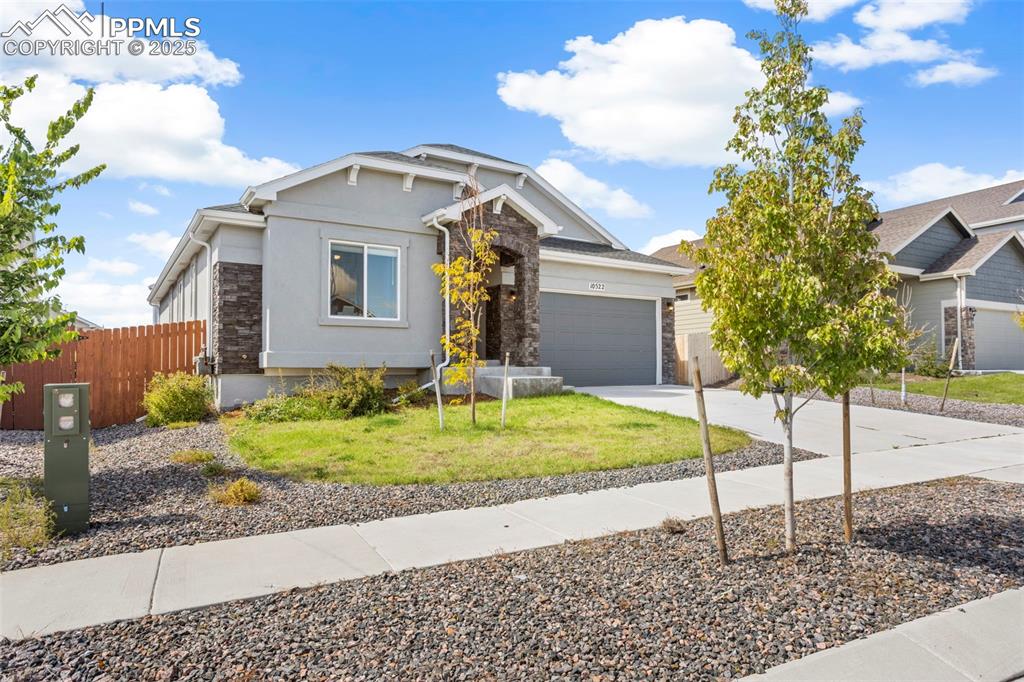 Craftsman-style house featuring concrete driveway, stucco siding, a garage, and stone siding
