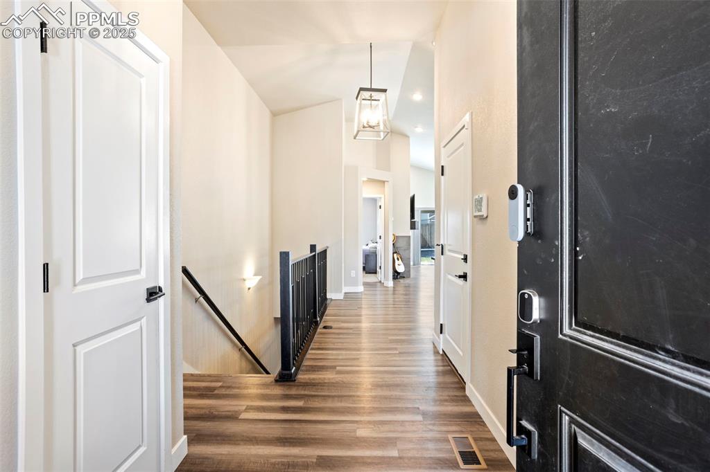 Foyer entrance with dark wood-style floors and high vaulted ceiling
