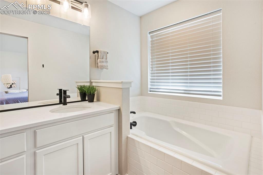 Full bath with vanity, a bath, and ensuite bath