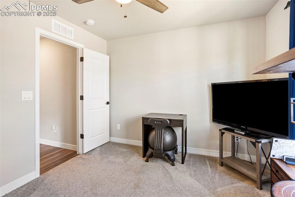 Living area with light colored carpet and ceiling fan