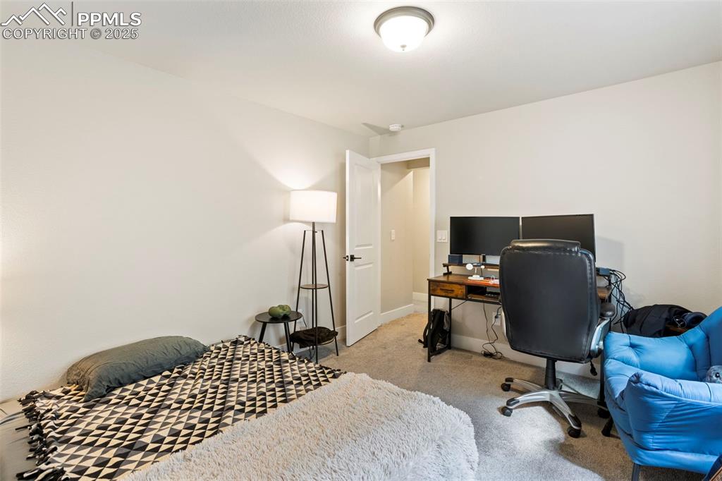 Bedroom featuring an office area and light colored carpet