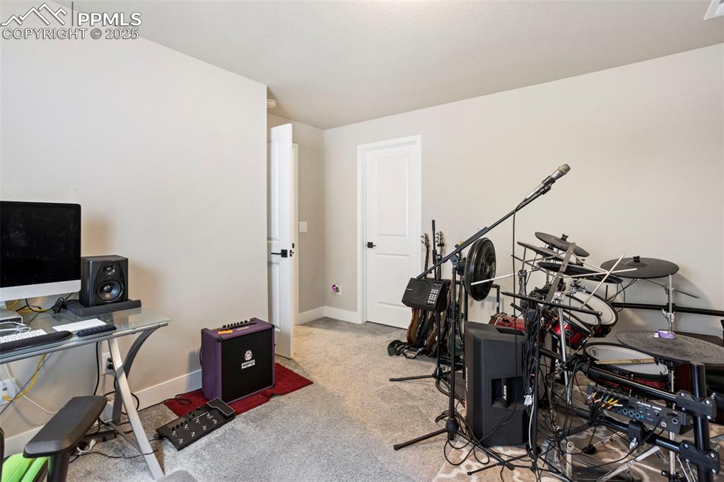 Office area featuring light colored carpet and baseboards