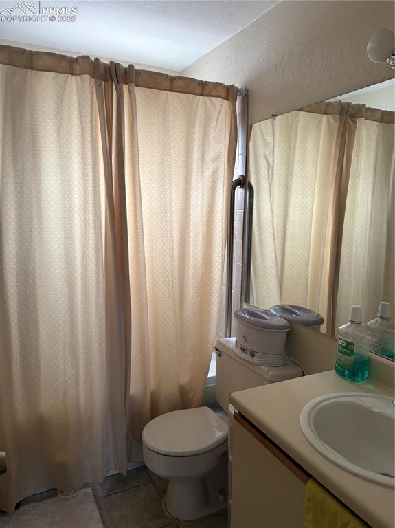 Full bathroom with vanity, tile patterned floors, and shower / bathtub combination with curtain