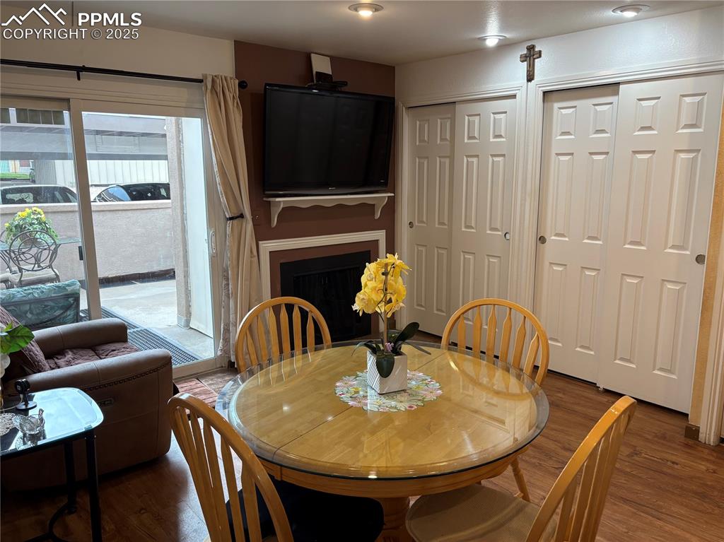 Dining room featuring wood finished floors, plenty of natural light, and a fireplace