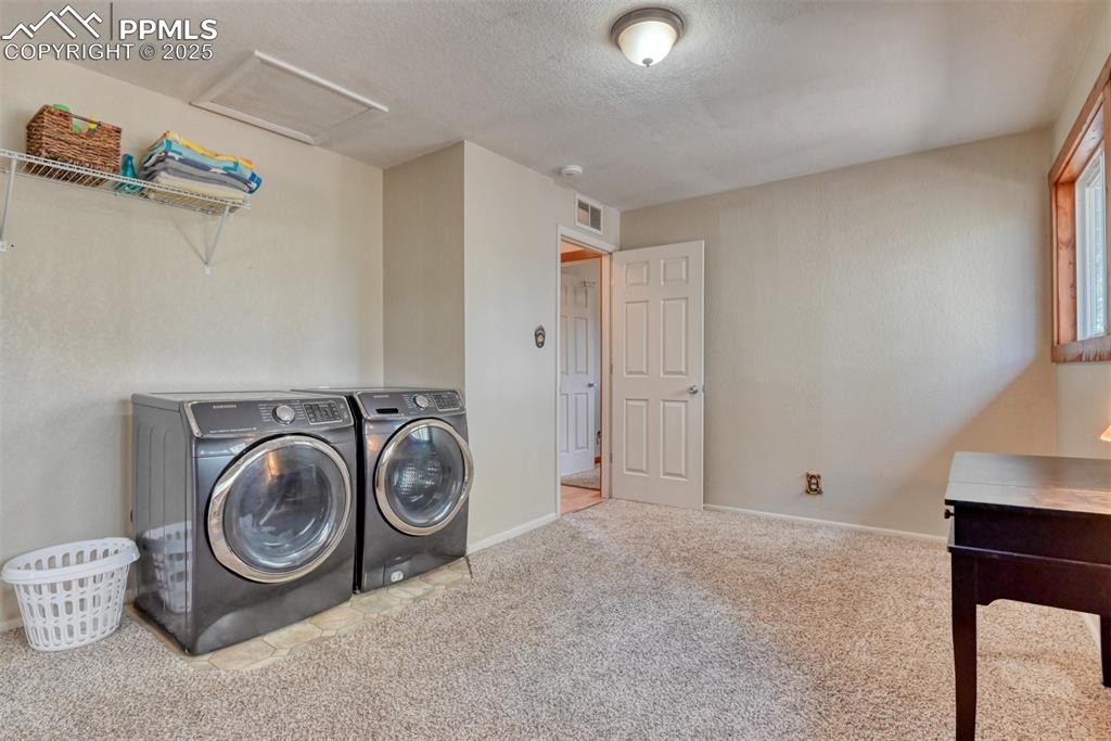 Laundry area with washer and dryer, carpet flooring, a textured ceiling, and attic access