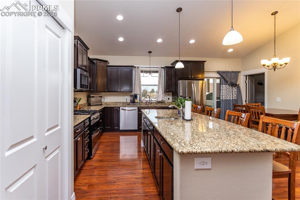 Kitchen with granite counters, gas range and an island with sink