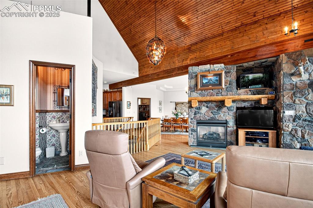 Living room on main level with double sided gas fireplace, walk out to spacious deck and vaulted ceilings.