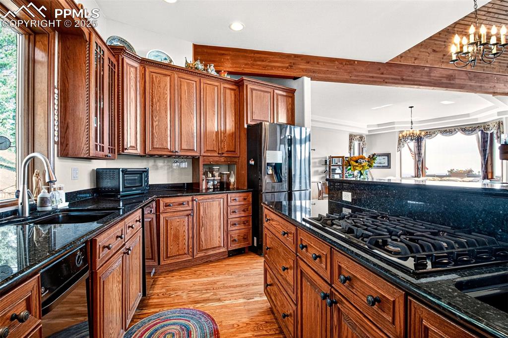 Kitchen with granite countertops, pantry, an island, breakfast area, a gas burning stove and custom cabinetry