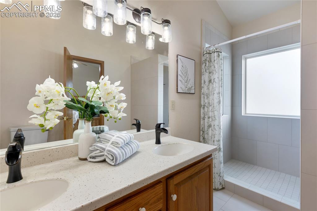 En-suite with custom tile walk-in shower, frosted glass provides natural light