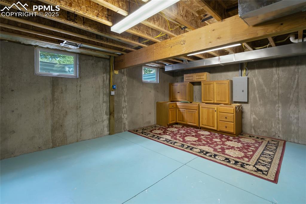 Unfinshed basement area with cabinets and flooring ready to get you started