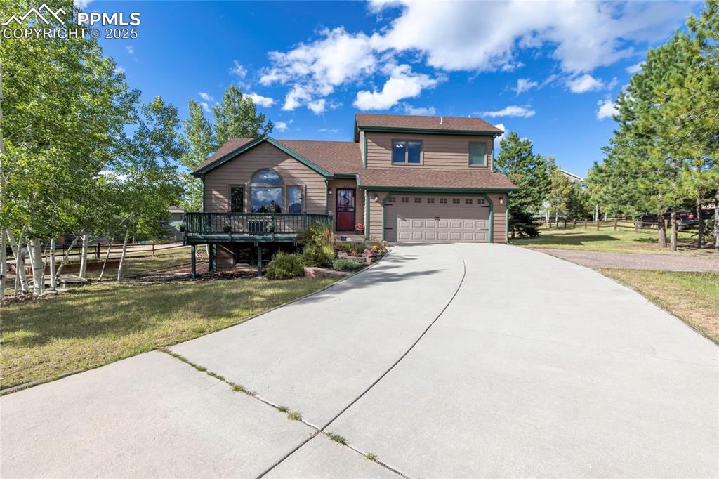 View of front of property featuring driveway, an attached garage, and roof with shingles