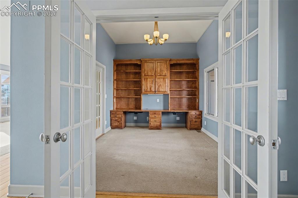 Office with built-in shelves and desk.