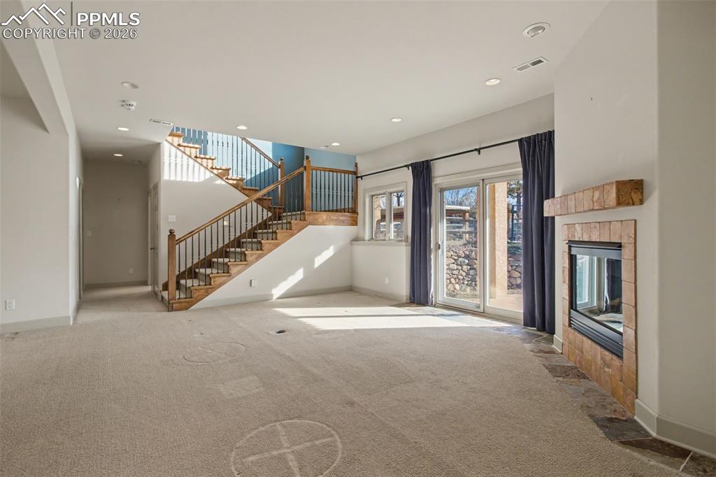 Family room in basement with view of staircase up to main level.