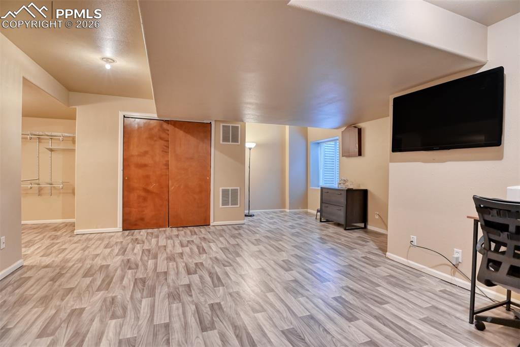 Unfurnished living room with light wood-type flooring and baseboards