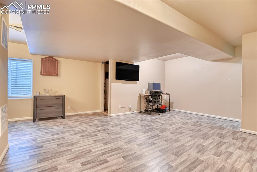 Additional living space with light wood-type flooring and baseboards