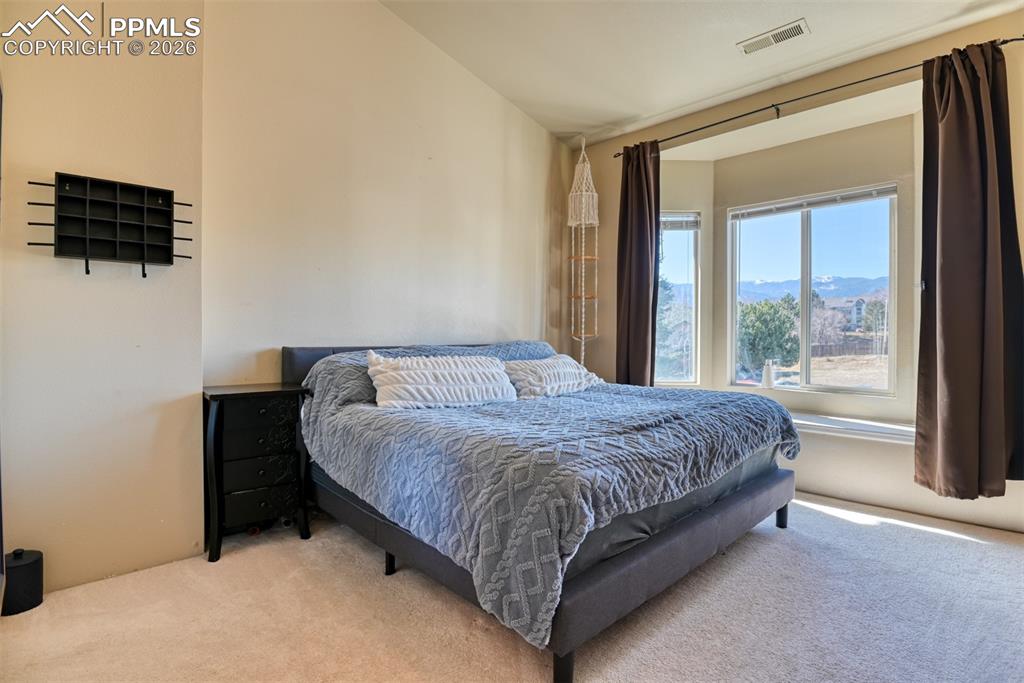Bedroom featuring light carpet and a mountain view