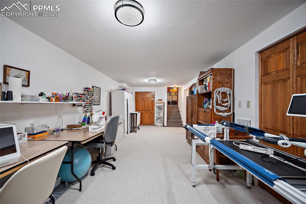 This room is the 3rd common living space and currently being used as a quilting room or hobby room. Would be a great recreation room with brick fireplace.   