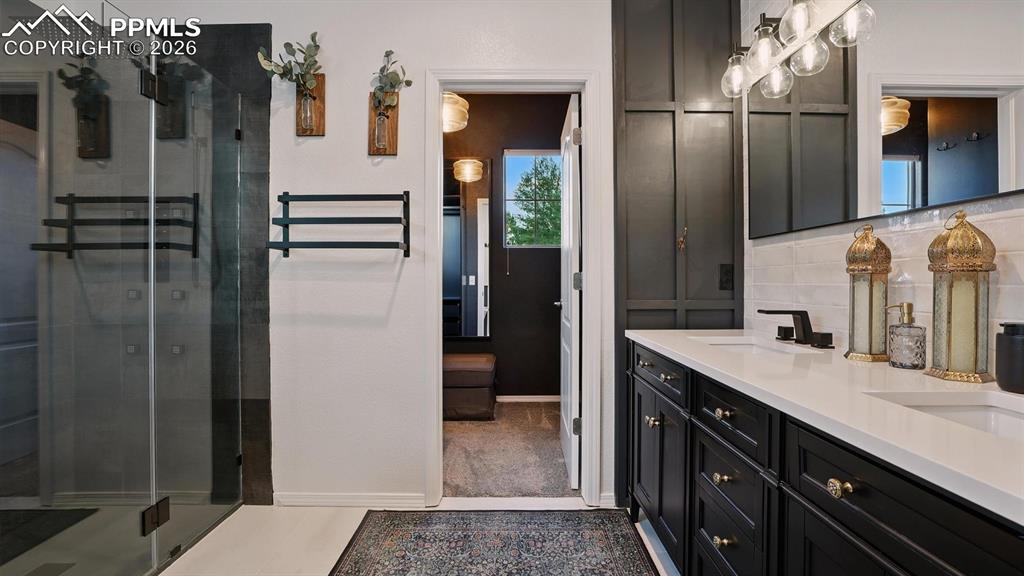 The Primary Bathroom has a tile floor, dual sink vanity, and walk in shower.