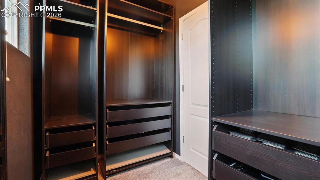 Walk in closet with custom organizers in the Primary Suite.
