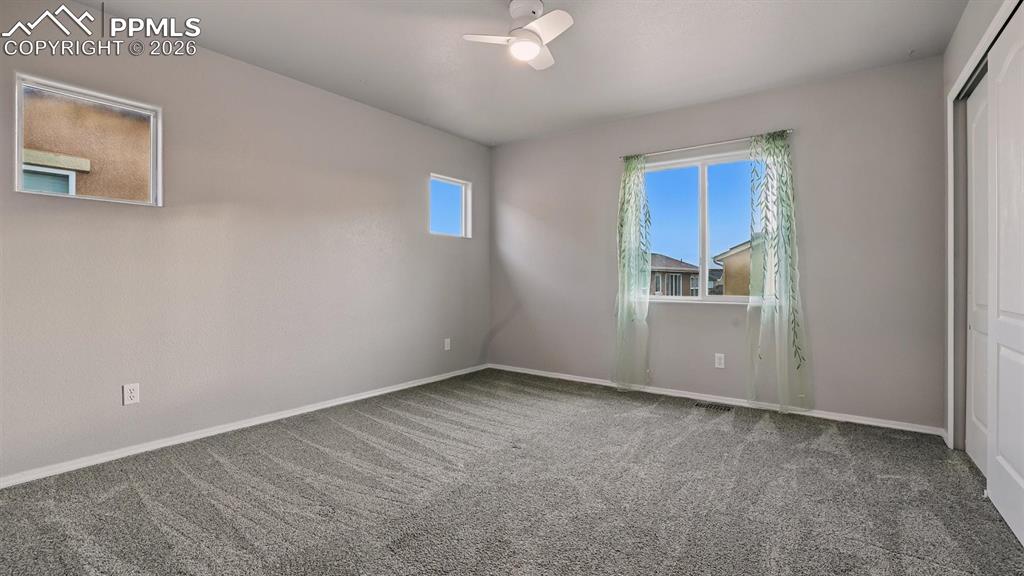 Upper Level Bedroom #2 with neutral carpet and ceiling fan.