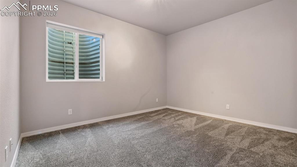 Basement Bedroom #4 with neutral carpet.