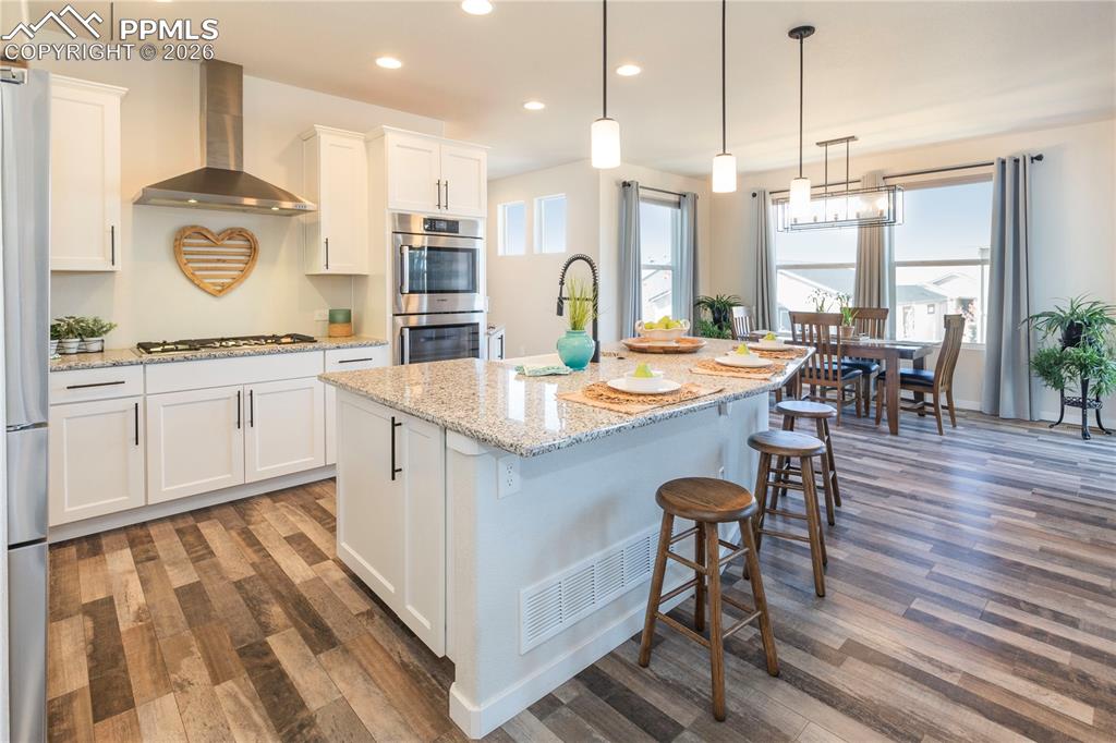5-burner Bosch gas range with a canopy range hood.