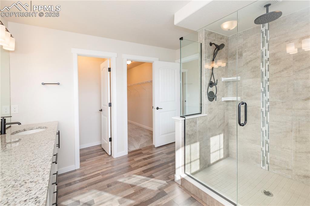 Two shower heads including an overhead Rain shower and a bench. 