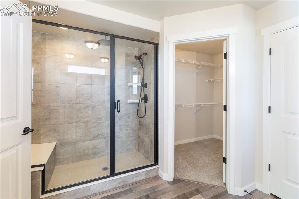 Jr. suite bathroom has a spa shower with 2 shower heads, a bench and a walk-in closet.