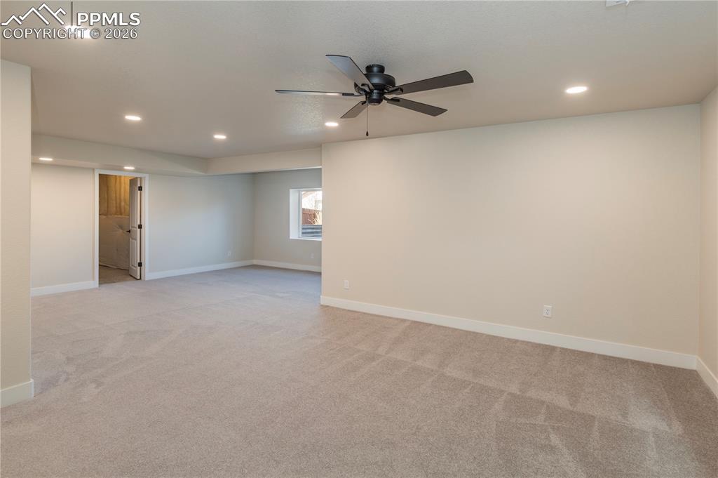 Newly finished rec room area feels bright and spacious. Unfinished storage room behind the door.