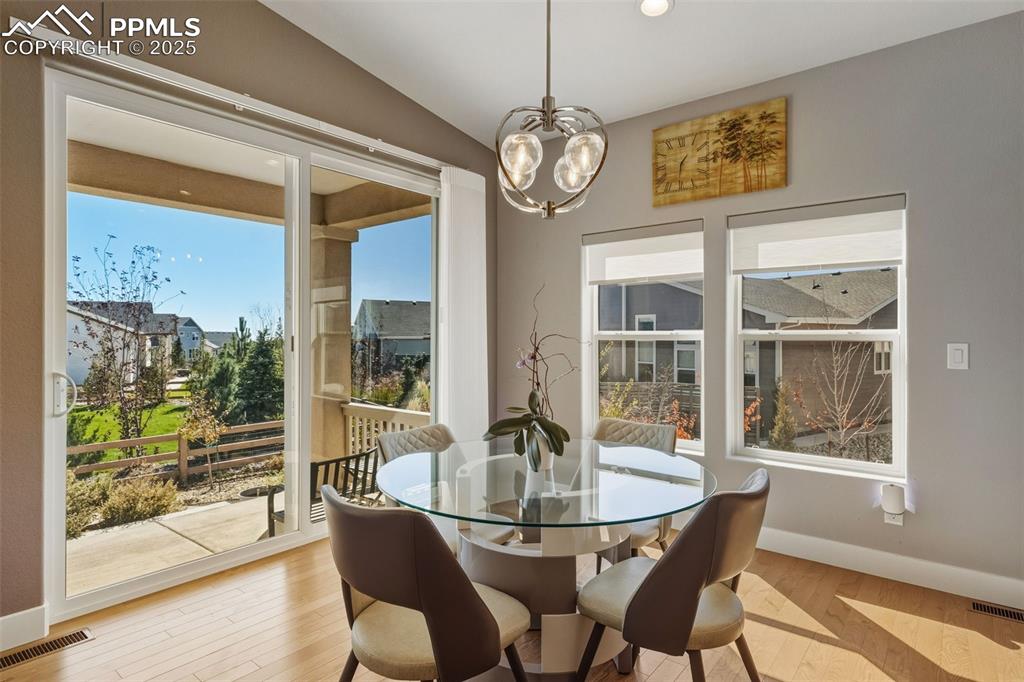 Dining space featuring plenty of natural light, hardwood / wood-style floors, recessed lighting, and a chandelier