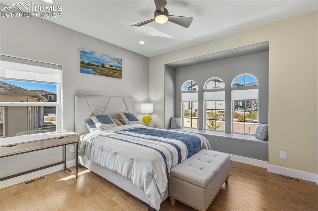 Bedroom with hardwood / wood-style floors, ceiling fan, and recessed lighting