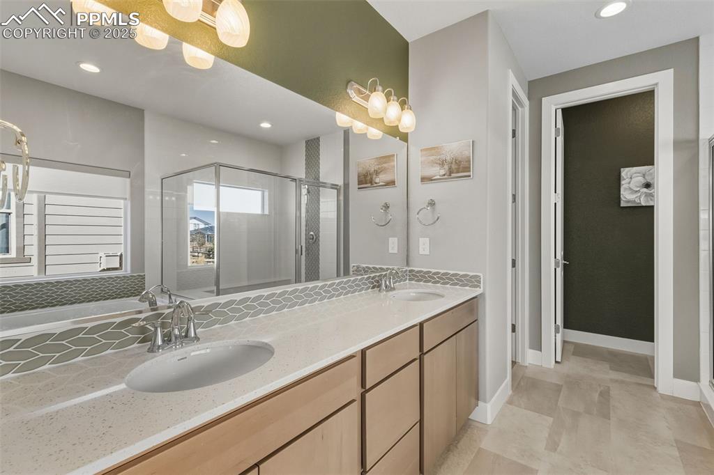 Full bathroom featuring a shower stall, recessed lighting, double vanity, and a bath